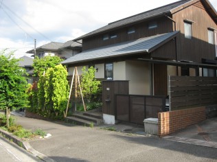 建物と合わせて作られたは木製の板塀風外構・・・いつかは腐ります。 門まで板張り