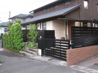 木製の板を張った感じを残したくて、アルミ材で濃いブラウンで板貼り。 門柱まで同素材です。