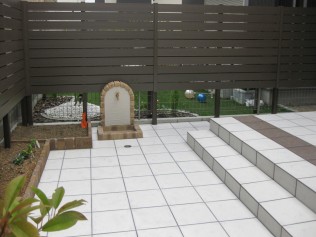 作った花壇に早速スコップが刺さっていました。うれしいです。 既存のテラスと目地合わせしタイル貼りのローテラスに。