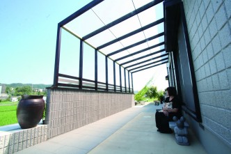 雨除けと目線除け、日除けも兼ねてココマⅡを設置。 風と光が通り、爽快なファサード空間を満喫できます。